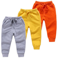 Baby cotton simple pants in gray, yellow, and orange colors with elastic waistbands.