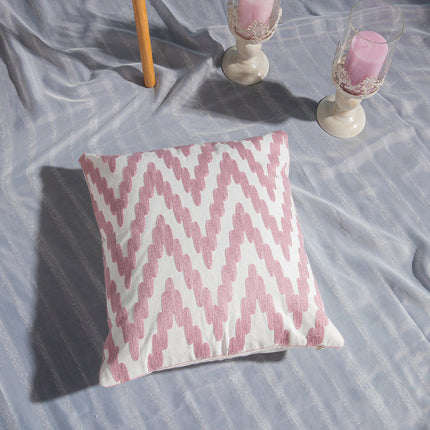 Geometric embroidered cotton cover on bed.