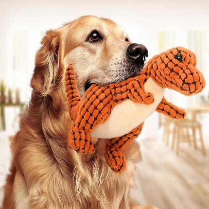 Golden retriever playing with a plush dinosaur pet toy, designed for durability and interactive fun.
